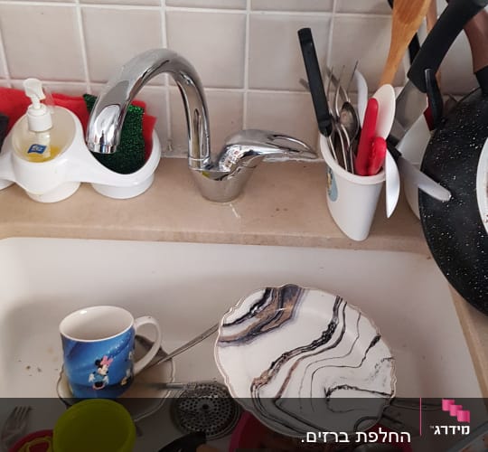 כיור עם כלים מלוכלכים וברז מטבח